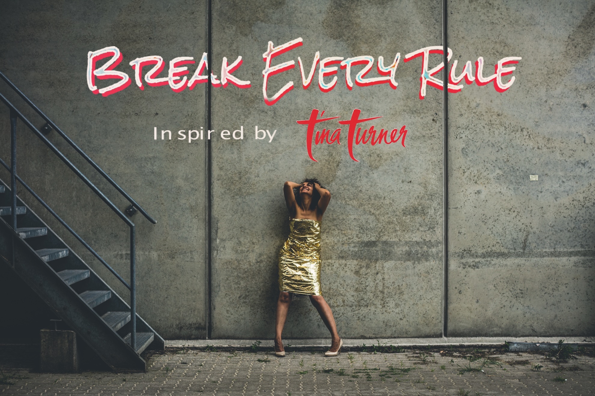 Promofoto: Sängerin im goldenen Kleid vor Betonwand, darüber der Schriftzug „Break Every Rule – Inspired by Tina Turner“